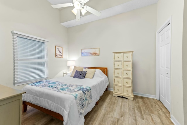 bedroom featuring ceiling fan, a closet, wood finished floors, and baseboards