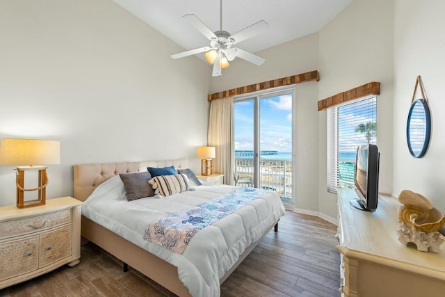 bedroom with baseboards, ceiling fan, wood finished floors, access to exterior, and high vaulted ceiling