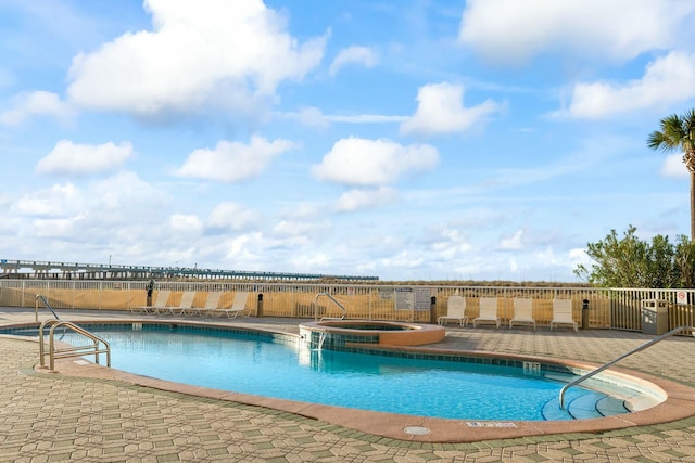 community pool featuring a patio and a hot tub