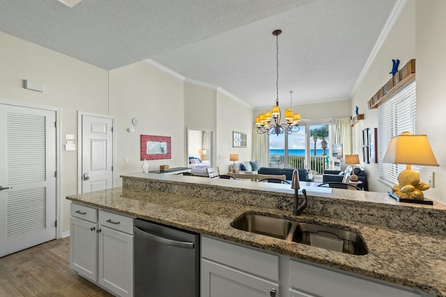 kitchen featuring dishwasher, light stone counters, ornamental molding, wood finished floors, and a sink