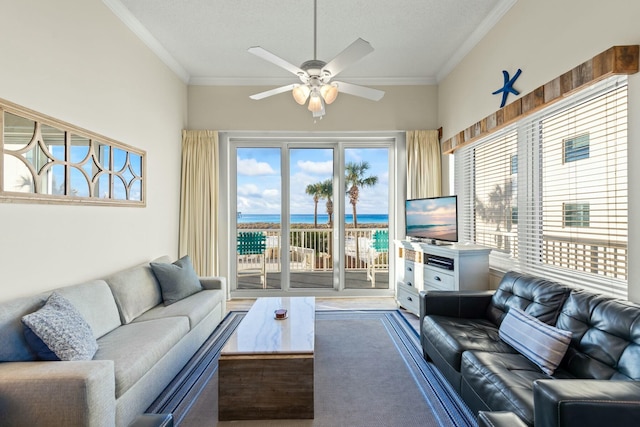 living room with carpet floors, a ceiling fan, and crown molding