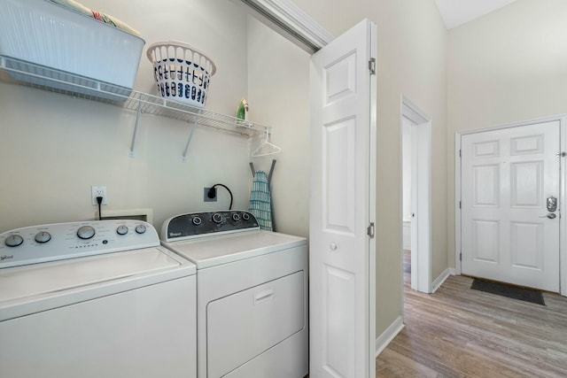 washroom featuring laundry area, independent washer and dryer, light wood-style flooring, and baseboards