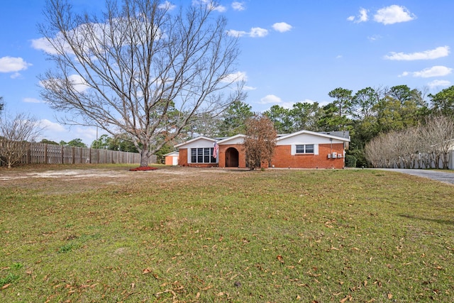 ranch-style house featuring a front yard, fence, and brick siding