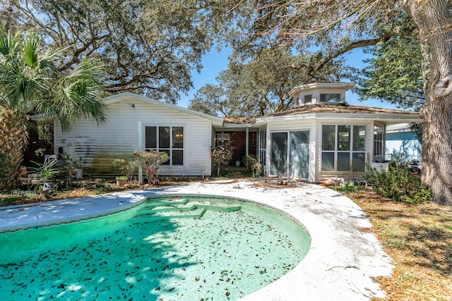 rear view of house featuring a sunroom