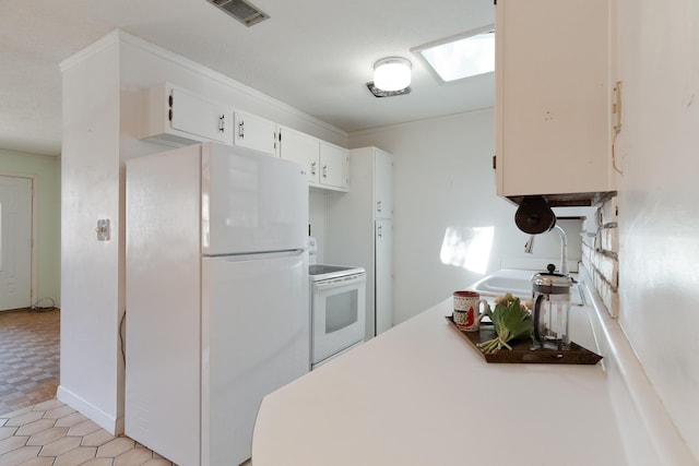 kitchen featuring visible vents, a sink, white cabinetry, white appliances, and a skylight