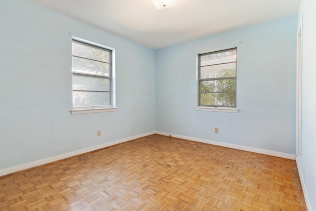 spare room featuring baseboards and a textured ceiling