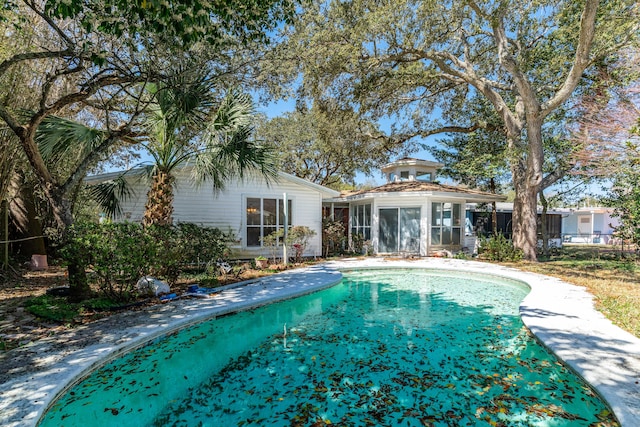 view of swimming pool with a sunroom