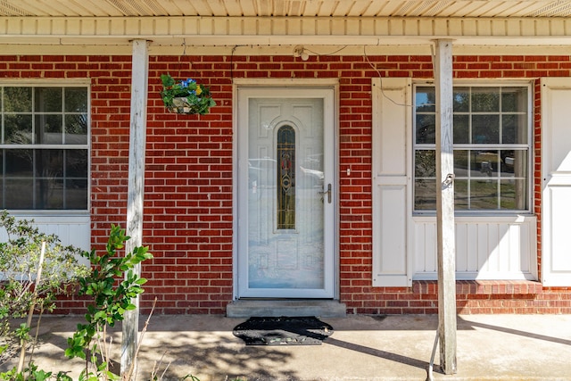 doorway to property with brick siding