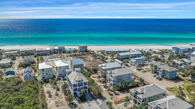 drone / aerial view featuring a water view, a residential view, and a view of the beach