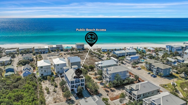 drone / aerial view featuring a beach view, a residential view, and a water view