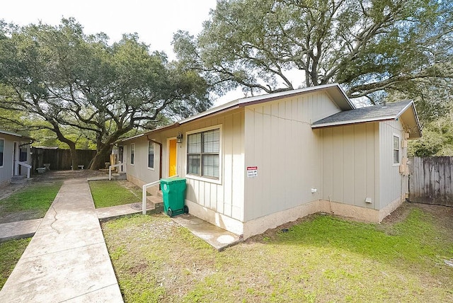 view of side of property featuring a fenced backyard and a lawn