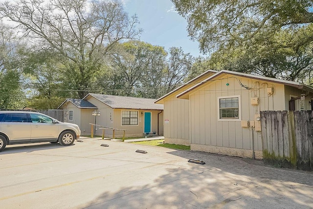 view of front of property featuring fence and concrete driveway