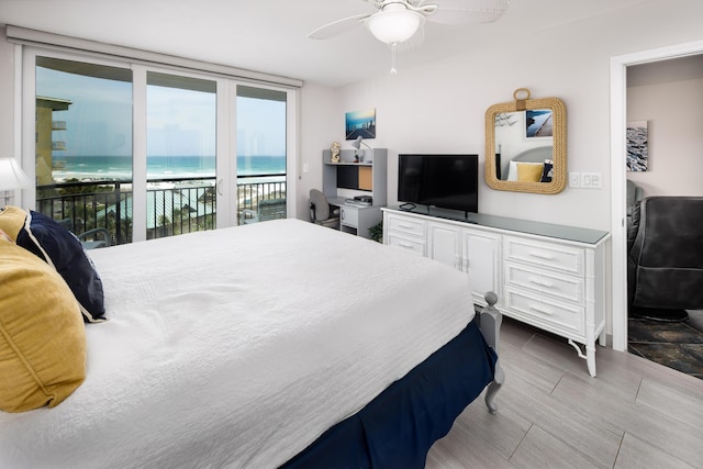 bedroom featuring access to exterior, a wall of windows, and a ceiling fan