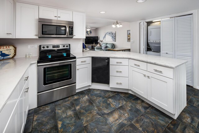 kitchen featuring stacked washer / drying machine, appliances with stainless steel finishes, stone finish floor, white cabinets, and a peninsula