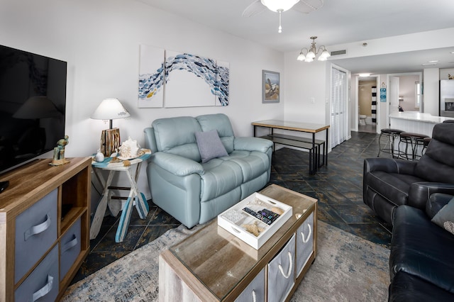 living area featuring stone finish flooring, visible vents, and a chandelier