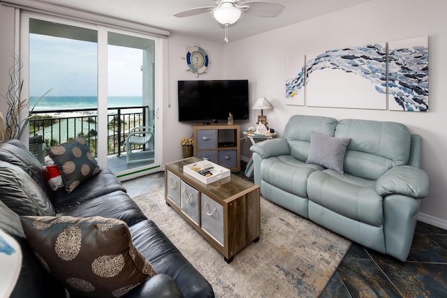 living room with a wall of windows, a ceiling fan, and baseboards