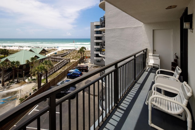 balcony with a water view and a beach view