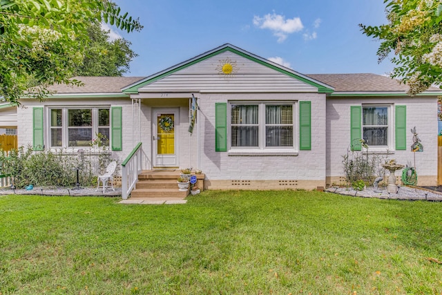 single story home featuring crawl space, brick siding, a shingled roof, and a front yard