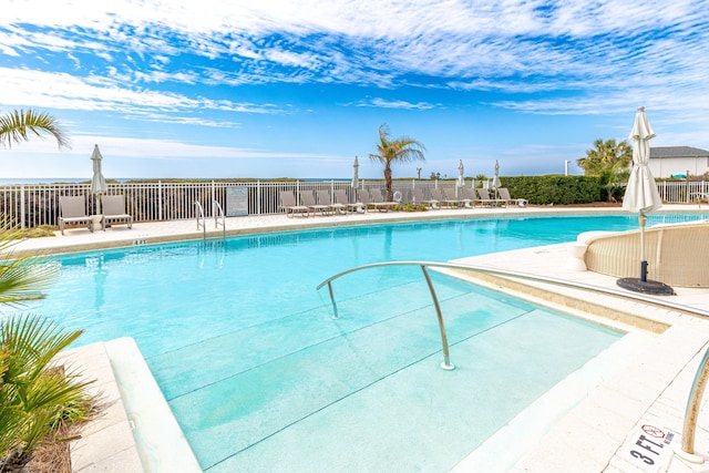 community pool with fence and a patio