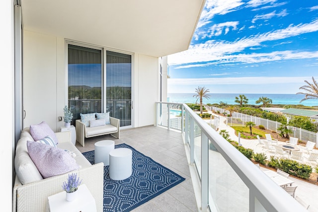 balcony with a water view and an outdoor living space