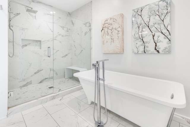 bathroom with marble finish floor, a freestanding tub, and a marble finish shower