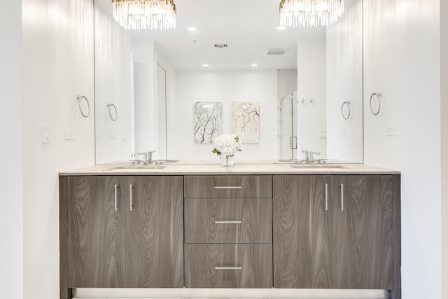 bathroom with double vanity, a sink, visible vents, and a notable chandelier