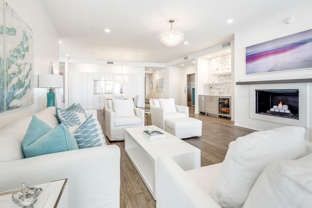 living room with a chandelier, recessed lighting, visible vents, and wood finished floors