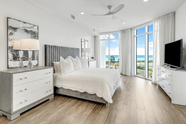 bedroom with recessed lighting, floor to ceiling windows, visible vents, and light wood finished floors