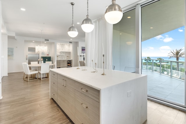 kitchen featuring modern cabinets, a kitchen island, expansive windows, light countertops, and light wood-type flooring