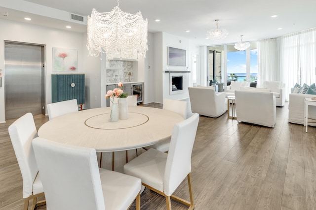 dining room featuring elevator, visible vents, a fireplace, and a chandelier