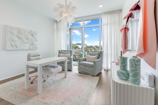 office area featuring an inviting chandelier, floor to ceiling windows, wood finished floors, and recessed lighting