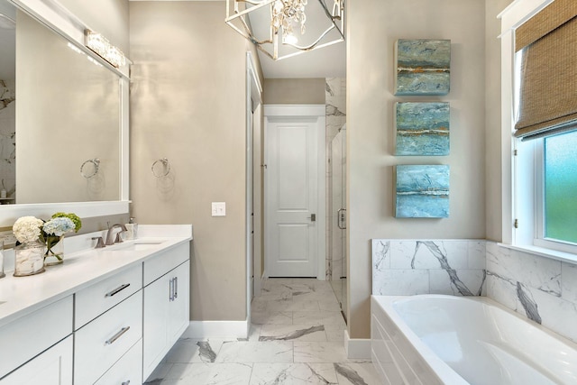 bathroom with a garden tub, marble finish floor, a stall shower, baseboards, and vanity