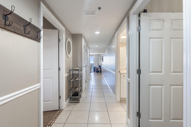 corridor featuring recessed lighting, visible vents, baseboards, and light tile patterned floors