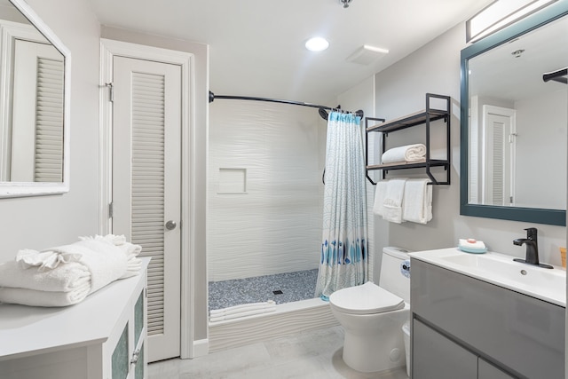 bathroom with a closet, a shower stall, toilet, and vanity