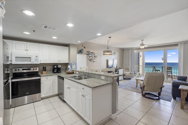 kitchen featuring visible vents, stainless steel appliances, a sink, and open floor plan