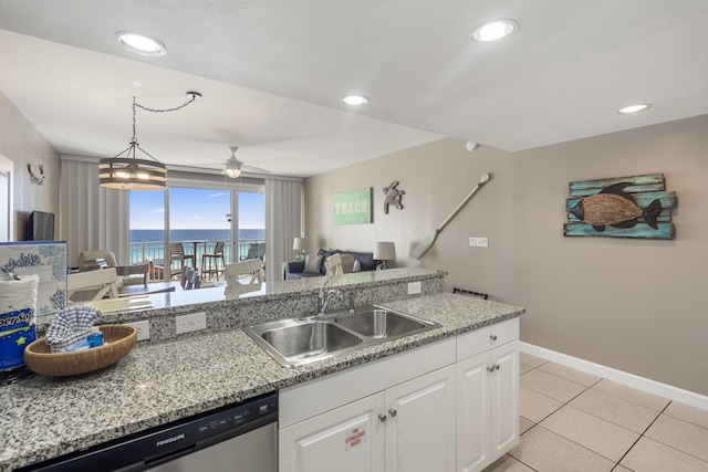 kitchen featuring light tile patterned floors, a sink, white cabinetry, hanging light fixtures, and stainless steel dishwasher