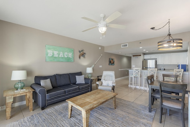 living room featuring ceiling fan, light tile patterned flooring, visible vents, and baseboards