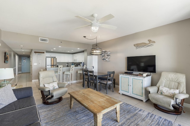 living room with light tile patterned floors, ceiling fan, visible vents, and baseboards