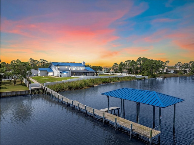 view of dock with a water view, a yard, and boat lift