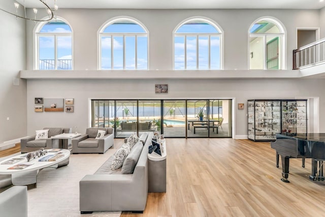 living area featuring a high ceiling, wood finished floors, and baseboards