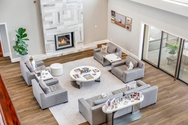 living room with a fireplace, baseboards, and wood finished floors