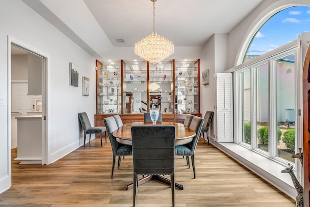 dining area with light wood-style floors, baseboards, visible vents, and a chandelier