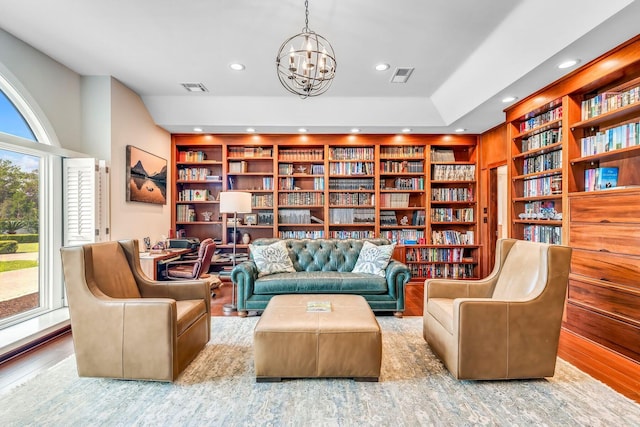 living area with recessed lighting, built in features, visible vents, and a notable chandelier