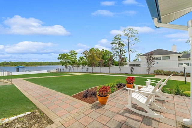 view of patio with a water view and fence