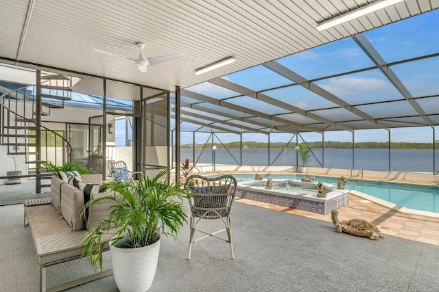 exterior space with an in ground hot tub, a water view, glass enclosure, and an outdoor pool