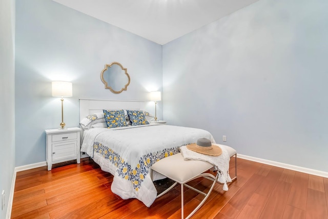 bedroom with baseboards and wood finished floors