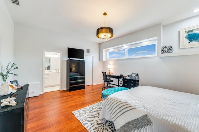 bedroom featuring light wood-style floors, visible vents, a notable chandelier, and baseboards