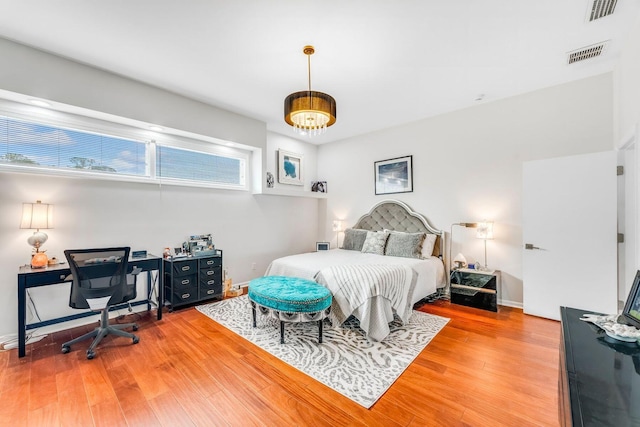 bedroom featuring light wood-type flooring, baseboards, and visible vents