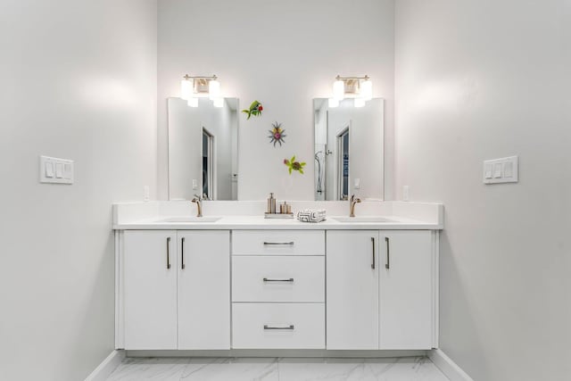 full bathroom featuring marble finish floor, a sink, and baseboards