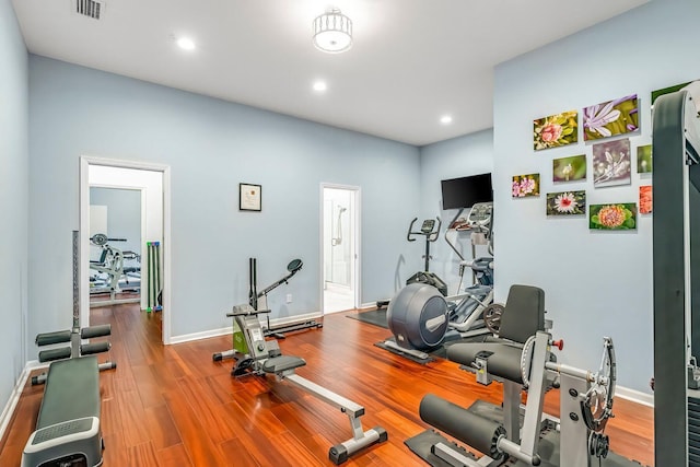 exercise area with baseboards, wood finished floors, visible vents, and recessed lighting